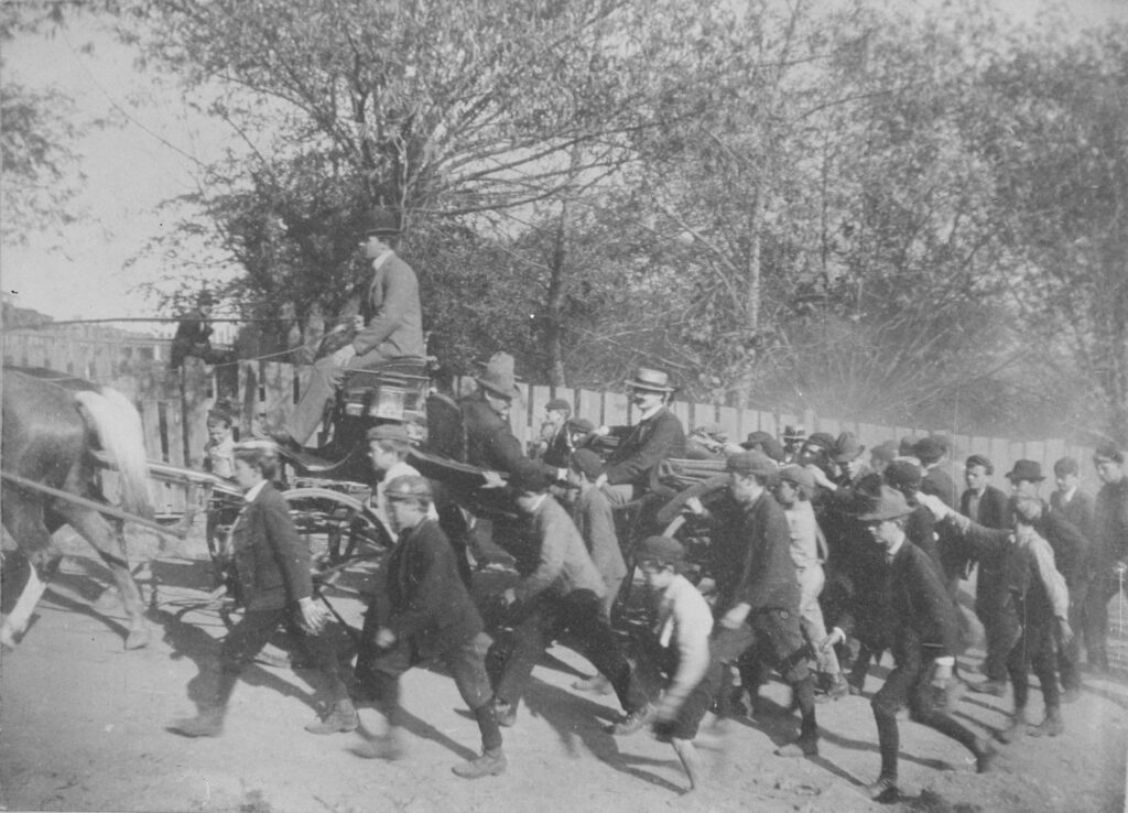 Shenandoah, Pennsylvania. John Mitchell, President of the UMWA (United Mine Workers of America), arriving in the coal town. His open four-horse carriage is surrounded by a crowd of boys.